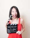Funny asian woman red dress with movie clapperboard on white Royalty Free Stock Photo