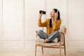 Funny asian woman using smartphone and wireless headphones at home Royalty Free Stock Photo