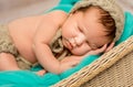 Funny asleep newborn baby in wicker cot Royalty Free Stock Photo