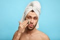 Funny awesome man with a towel on his head putting a mask on his face Royalty Free Stock Photo