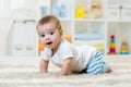 Crawling funny baby boy in nursery at home Royalty Free Stock Photo