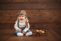 Funny baby boy pilot aviator with airplane laughing Royalty Free Stock Photo