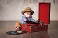 Funny baby boy in retro hat with vinyl record and gramophone Royalty Free Stock Photo