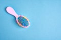 Funny baby comb with multi-colored plastic wavy bristles lies on a blue background Royalty Free Stock Photo