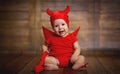 Funny baby in devil halloween costume on wooden background Royalty Free Stock Photo