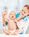 Funny baby and doctor pediatrician. doctor listens to the heart