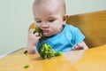 Funny baby eating broccoli Royalty Free Stock Photo