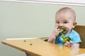 Funny baby eating broccoli Royalty Free Stock Photo