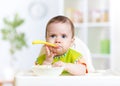 Funny baby eating food on kitchen Royalty Free Stock Photo