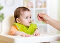 Funny baby eating food on kitchen Royalty Free Stock Photo