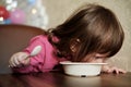 Funny baby eats porridge with spoon