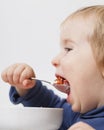 Funny Baby eats vegetable soup spoon Royalty Free Stock Photo