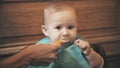 Funny baby girl eats unappetizing meal and frowns, close-up