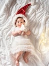 Funny baby girl lying on the bed in Christmas clothes Royalty Free Stock Photo