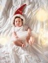 Funny baby girl lying on the bed in Christmas clothes Royalty Free Stock Photo