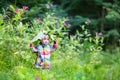 Funny baby girl playing peek a boo in a park under huge leaves Royalty Free Stock Photo