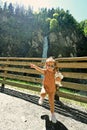 Funny baby girl in sunglasses against waterfall in Liechtensteinklamm or Liechtenstein Gorge, Austria