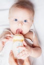 Funny baby holding a bottle with mothers breast milk Royalty Free Stock Photo
