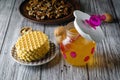 Funny baby jar of honey with a pink honey spoon and walnuts and waffle cookies