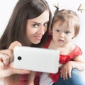 Funny baby and mother make selfie on mobile phone Royalty Free Stock Photo