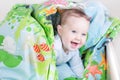 Funny baby playing in bed under blue blanket Royalty Free Stock Photo