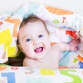 Funny baby playing peek-a-boo under a colorful blanket Royalty Free Stock Photo