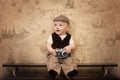 The funny baby traveler with a retro camera