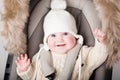 Funny baby in a warm hat sitting in a stroller Royalty Free Stock Photo