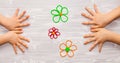 Funny banner wooden background with kids hands and colorful flowers from plasticine