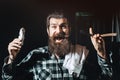 Funny bearded Barber with scissors and straight razor in barber shop. Vintage barbershop, shaving. Portrait bearded man