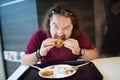 Funny bearded man enjoying a meal at fast food restaurant Royalty Free Stock Photo