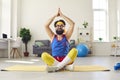 Funny man sitting in easy yoga pose with arms raised, learning to do breathing exercise and meditate Royalty Free Stock Photo