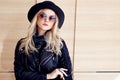 Funny and beautiful blonde in sun glasses and a hat. Trendy girl portrait outdoor. Holds hat Royalty Free Stock Photo