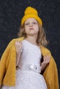 A funny beautiful five-year-old girl in a yellow knitted hat Royalty Free Stock Photo