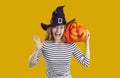 Funny beautiful young woman in witch hat holding Halloween pumpkin and screaming Royalty Free Stock Photo