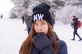 Beauty atractive woman with winter fashion clothing is making funny face in snow skii resort bitting her hand