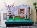 Funny bench in the form of a colored cow and calves on the street in Orvieto Italy.