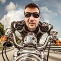 Funny Biker in sunglasses and leather jacket racing on mountain