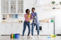 Funny black couple singing songs while cleaning kitchen, copy space Royalty Free Stock Photo