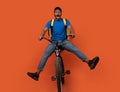 Funny black delivery man riding bicycle at studio Royalty Free Stock Photo