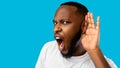 Funny Black Guy Listening Holding Hand Near Ear, Blue Background