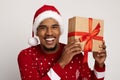 Funny black guy Santa Claus holding Christmas present by ear Royalty Free Stock Photo