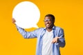 Funny Black Man Holding Speech Bubble Over Yellow Studio Background