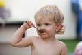 Funny blond baby eating chocolate Royalty Free Stock Photo