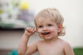 Funny blond baby eating chocolate Royalty Free Stock Photo
