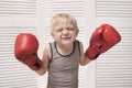 Funny blond boy in red boxing gloves. Sports concept Royalty Free Stock Photo