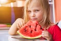 Funny blond child portrait with watermelon indoors. Pretty little toddler girl 4 year eating watermelon close-up at home Royalty Free Stock Photo