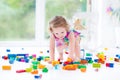 Funny blond toddler girl sitting on floor in mess Royalty Free Stock Photo