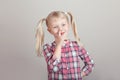 funny blonde Caucasian preschool girl picking nose