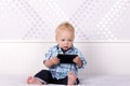 Funny blonde toddler watching cartoons in smartphone. Funny baby boy playing with phone. Royalty Free Stock Photo